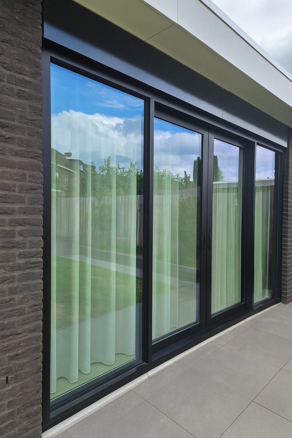 Moderne schuifpui met slanke profielen en geïntegreerde zonwerende beglazing
