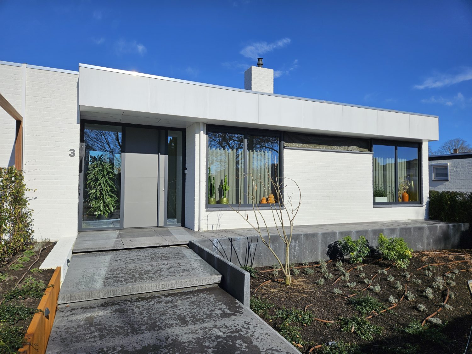 Moderne aluminium kozijnen met grote glaspartij in bungalow renovatie Deurne
