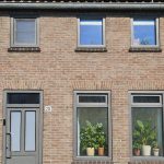 Kunststof blokkozijnen in kwartsgrijs met houtnerf en aluminium schuifpui in aanbouw